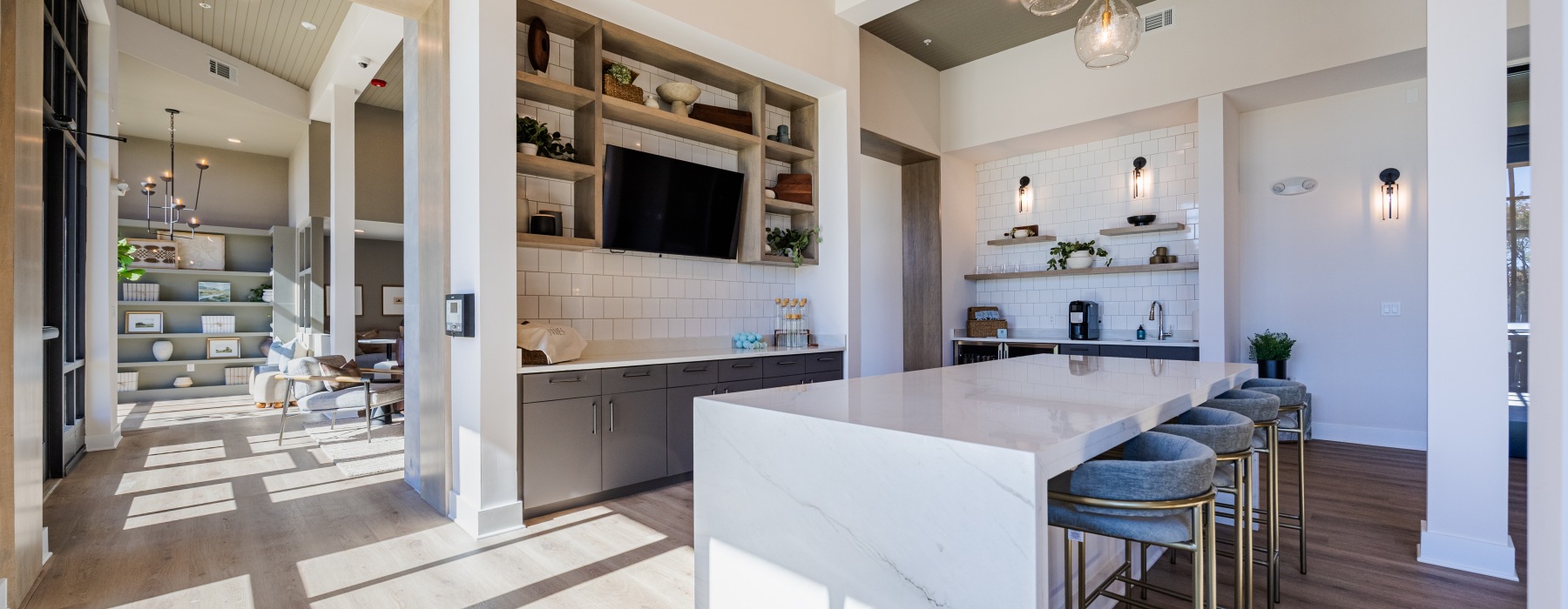 Luxury apartment clubhouse interior with communal kitchen, seating, and lounge space at The James Charlottesville