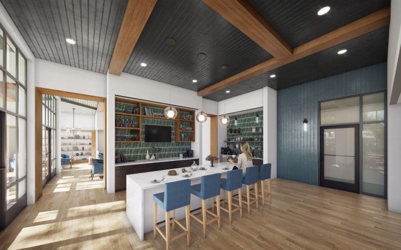 a well-lit room with a kitchen and a media area