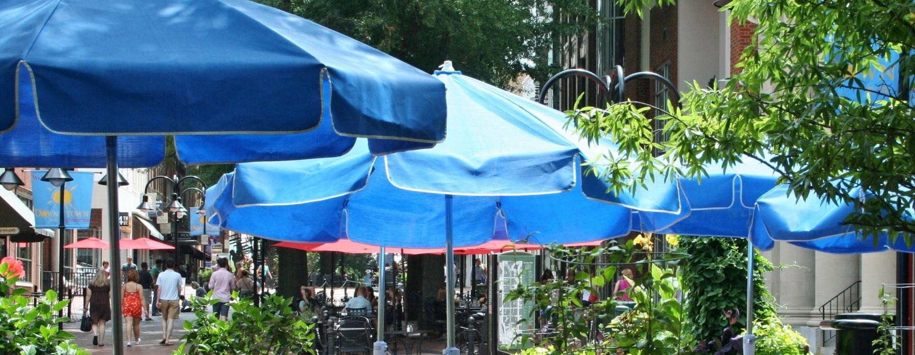 tables and chairs under umbrellas